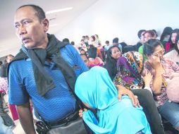 Familiares de los 162 pasajeros esperan noticias del avión desaparecido de AirAsia en el aeropuerto de Juanda, Surabaya, Indonesia. EFE /