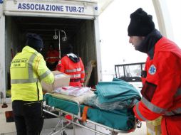 Voluntarios de la Cruz Roja italiana acuden al campamento donde se reciben a los pasajeros rescatados del ''Norman Atlantic''. AFP / C. Hermann