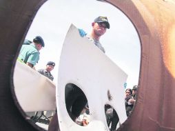 SURABAYA. Personal del buque de guerra indonesio KRI Bung Tomo muestra restos del fuselaje del avión de AirAsia. EFE /