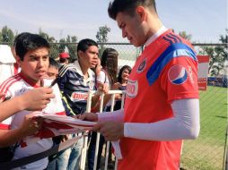 Jugadores de Chivas firman camisetas a seguidores del equipo luego del entrenamiento. TWITTER / ‏@Chivas