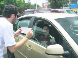 Mantas, pendones y comerciales en radio y TV no son suficientes. Mandan brigadas a las calles para pegar 'calcas' en los automóviles. EL INFORMADOR / ARCHIVO