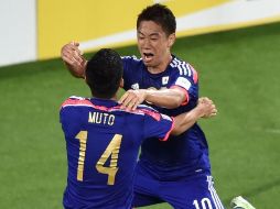Yoshinori Muto (izq) celebra una anotación con su compañero Shinji Kagawa. AFP / T. Karanikos