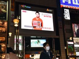 Transeúntes observan una pantalla en Tokio que muestra a uno de los dos rehenes que el EI amenaza con asesinar. AFP / Y. Tsuno
