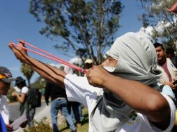 Mientras la gente se defendía con piedras, los militares y policías federales utilizaban sus escudos y toletes. AFP / J. Guerrero