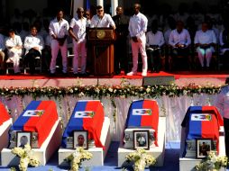 Los féretros fueron cubiertos con la bandera haitiana sobre un escenario en el parque Champ de Mars de la capital. EFE / J. Jacques