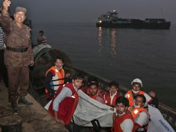 Rescatistas de Bangladesh cargan el cuerpo de una de las víctimas del ferry. AP / A. Ahad