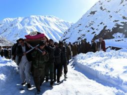 Hombres afganos cargan cuerpo de víctima de las avalanchas después de funeral. AFP / S. Marai