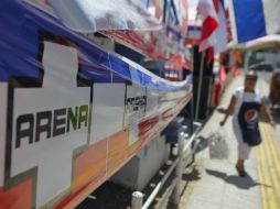 Una mujer camina junto a propaganda del Partido alianza Republicana Nacionalista. AFP / ARCHIVO