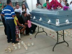 En torno al féretro, los hermanos del migrante michoacano montaron guardia, atrás sus hermanas permanecían junto a sus padres. EFE /