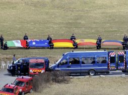 La bandera mexicana está sujeta por varios gendarmes y acompañada de otras banderas como la de Alemania, Australia y España. AFP / J. P. Clatot