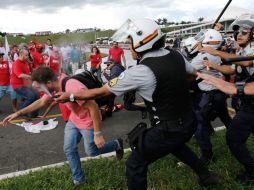 Los policías usaron gas pimienta y bastones para impedir que los sindicalistas entraran al edificio legislativo. AP / E. Peres