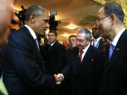 Barack Obama (i) saluda a su homólogo cubano, Raúl Castro (c), con el secretario general de la ONU, Ban ki-moon (d), como testigo. EFE /