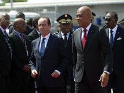 El presidente haitiano, Michel Martelly, recibió personalmente al mandatario francés, con la visita finalizará tour por Latinoamérica. AFP / H. Rematal