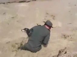 Sin dudarlo, policías de Colombia bajan al cause del río para rescatar al perro que era arrastrado por la corriente de agua. YOUTUBE / POLICIA DE COLOMBIA