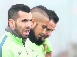 Carlos Tevez (izq.) y el chileno Arturo Vidal (centro), titulares habituales de la Juve, arrancarían como suplentes ante el Napoli. AFP / M. Bertorello