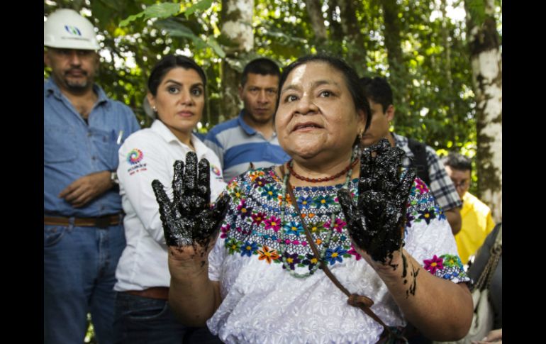 En la imagen, Menchú muestra sus manos tras introducirlas en el pozo Aguarico 4, ubicado en en medio de la selva amazónica. EFE / J. Jácome