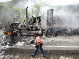 Un tráiler, color rojo, es calcinado incluso con la mercancía encima. Transportaba bultos de cemento. AP / R. Blackwell