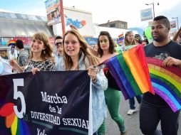 Miembros de la comunidad LGTB recorren las principales calles de la ciudad portando pancartas. EFE / P. Orozco