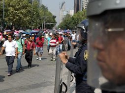 Cientos de maestros de la CNTE provenientes de varios estados mexicanos son custodiados por la policía durante sus protestas. EFE / A. Cruz