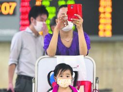 Prevención. Pasajeros en el Aeropuerto Internacional Gimpo, en la capital surcoreana, toman medidas contra un posible contagio. AFP /