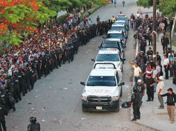 Policías federales resguardan a un grupo de maestros que realizaron la evaluación docente. EFE / J. Hernández