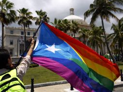 El fallo del Tribunal Supremo de EU a favor del matrimonio gay es celebrado por una mujer en San Juan que ondea una bandera. EFE / T. Llorca