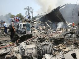 Equipos de rescate trabajan en la zona donde cayó el avión. AP /