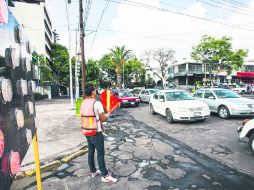 Indicaciones. Un hombre señala, con una bandera naranja, que la calle está cerrada. EL INFORMADOR / P. Franco