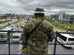 Un soldado de la Policía Militar de Colombia hace guardia en un puente peatonal que se alza sobre una carretera que lleva a Bogotá. AFP / G. Legaria
