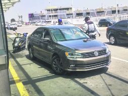 Un elemento de seguridad del Aeropuerto tapatío le pide a un chofer de Uber que se retire, pues no puede esperar ahí por clientes. EL INFORMADOR / G. Jáuregui