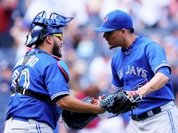 Roberto Osuna (derecha) celebra con Dioner Navarro el triunfo por blanqueada sobre los Yankees. AFP /