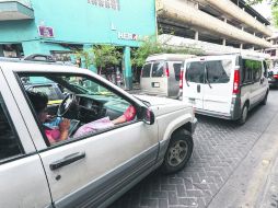 Ante el tráfico que ya es común en calles como López Cotilla, una mujer decidió ir más cómoda en el asiento de acompañante. EL INFORMADOR / A. García