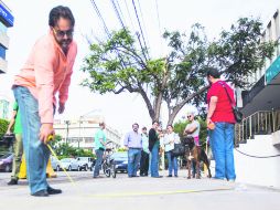 Carlos Romero Sánchez, integrante del Observatorio Ciudadano de Movilidad, hace mediciones sobre irregularidades en una de las aceras. EL INFORMADOR / P. Franco