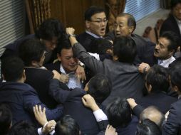 La aprobación se produjo en medio del caos luego que los legisladores de oposición subieron a la tribuna para anular la votación. AP / E. Hoshiko