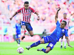 El delantero de Chivas, Marco Fabián, intenta quitarse una fuerte barrida del defensa poblano Ramón Arias. MEXSPORT / A. Macías