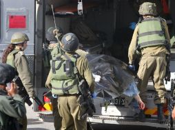 Fuerzas de seguridad israelíes trasladan el cadáver a la morgue. AFP / H. Bader