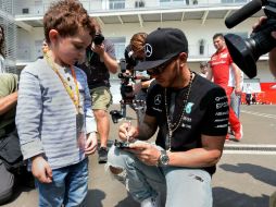 Lewis Hamilton firma un auto de juguete a un pequeño en la zona de Paddock del Autódromo Hermanos Rodríguez. EFE /  A. Estrella