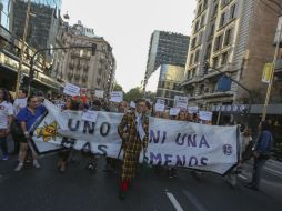Durante la marcha de este miércoles abundaron los pines que denuncian el maltrato hacia las mujeres. EFE / D. Fernández