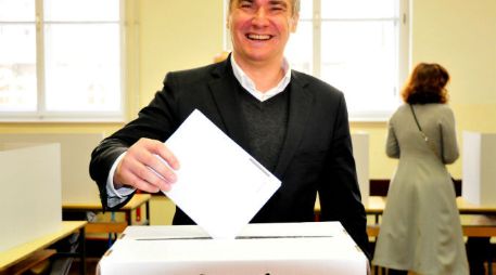 Zoran Milanovic, primer ministro de Croacia, deposita su papeleta en la urna; él es líder del Partido Social Democrático del país. EFE / I. Kupljenik