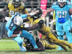EverBank Field. Marcus Mariota (izq.), de los Titans, es detenido por la defensa de los Jaguars. AP / B. Blanco
