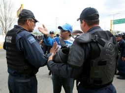 En la colonia ''Las Flores'', los integrantes de la Sección 22 se encuentran frente a un bloque de la Policía Federal. SUN / J. Reyes