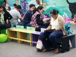 Mientras esperan a sus hijos, padres aprovechan los libros que se encuentran en el lugar. ESPECIAL / Mar Adentro