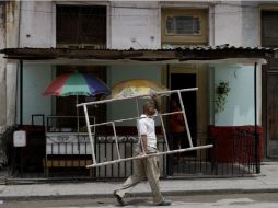 Población activa. Un trabajador con un andamio en La Habana. AFP / F. Reyes