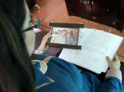 Guadalupe Gutiérrez ve la foto de sus padres junto al acta de defunción de su papá Roberto, quien falleció hace un año. EL INFORMADOR / A. Hinojosa
