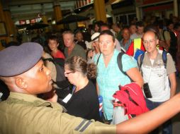 Ante la mirada de un policía keniano, pasajeros se dirigieron a hoteles cercanos en lo que el paquete sospechoso era examinado. AP /