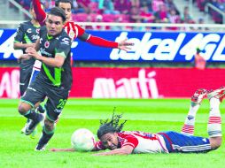 Carlos Peña (sobre el suelo) no logra conectar el balón de buena forma ante la marca de Veracruz en el Omnilife. MEXSPORT /