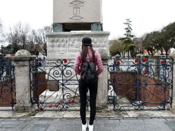 Una turista observa las flores depositadas en homenaje a las víctimas en uno de los obeliscos de la explanada de Sultanahmet. EFE / S. Suna