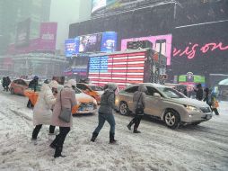 Nueva York. Varias personas transitan a prisa por las calles de Times Square durante las primeras horas de la tormenta. AFP /
