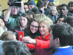 La demócrata Hillary Clinton (de rojo) se toma una fotografía durante su visita a la Universidad Howe Hall en Ames. EFE /