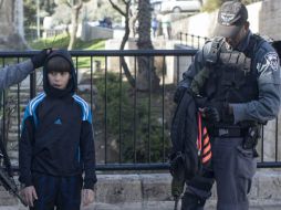 Policías registran a un joven palestino sospechoso en la inmediaciones de Damasco como parte de las medidas de seguridad. EFE / A. Safadi